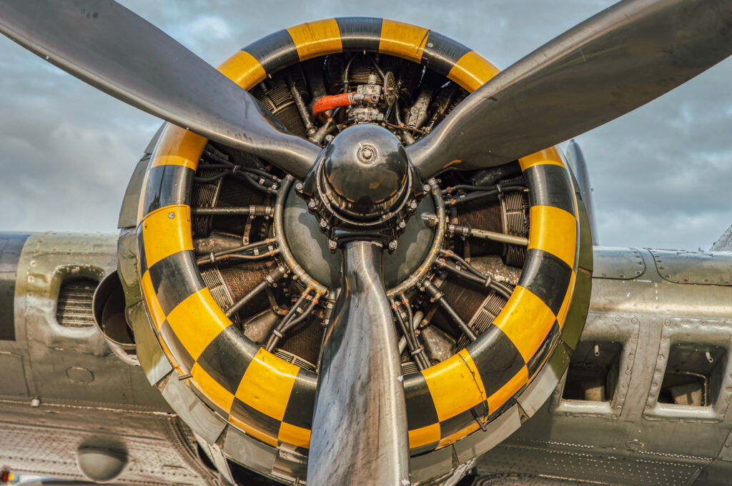 9 cylinder combustion engine with yellow, black square pattern. nine chamber, air cooled radial motor with propeller closeup on heavy military bomber airplanes or aircraft used in the second world war
